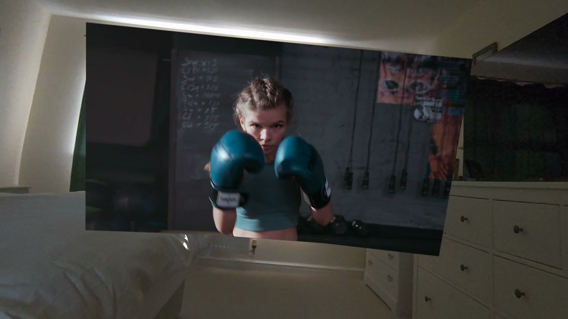 Large virtual screen showing a boxer, with the bedroom visible around it through Virtual Desktop passthrough